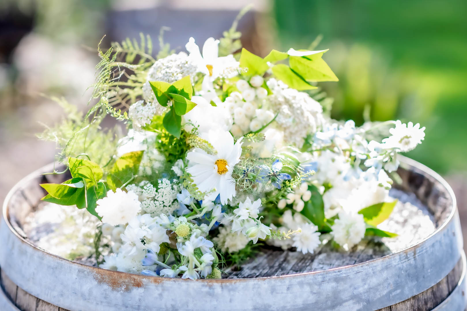 Wildflower wedding bouquet set on top of a wine barrel.