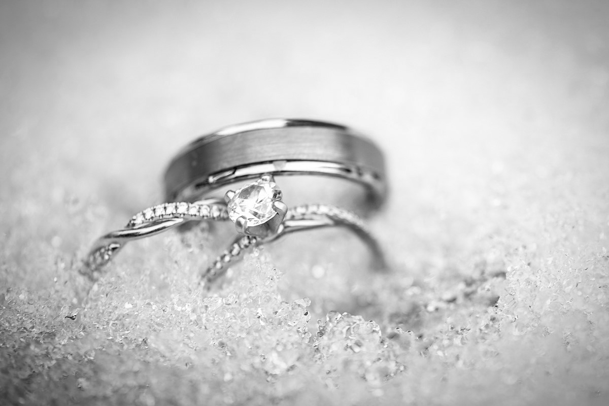 wedding rings tucked into a bed of snow on at a winder wedding. 