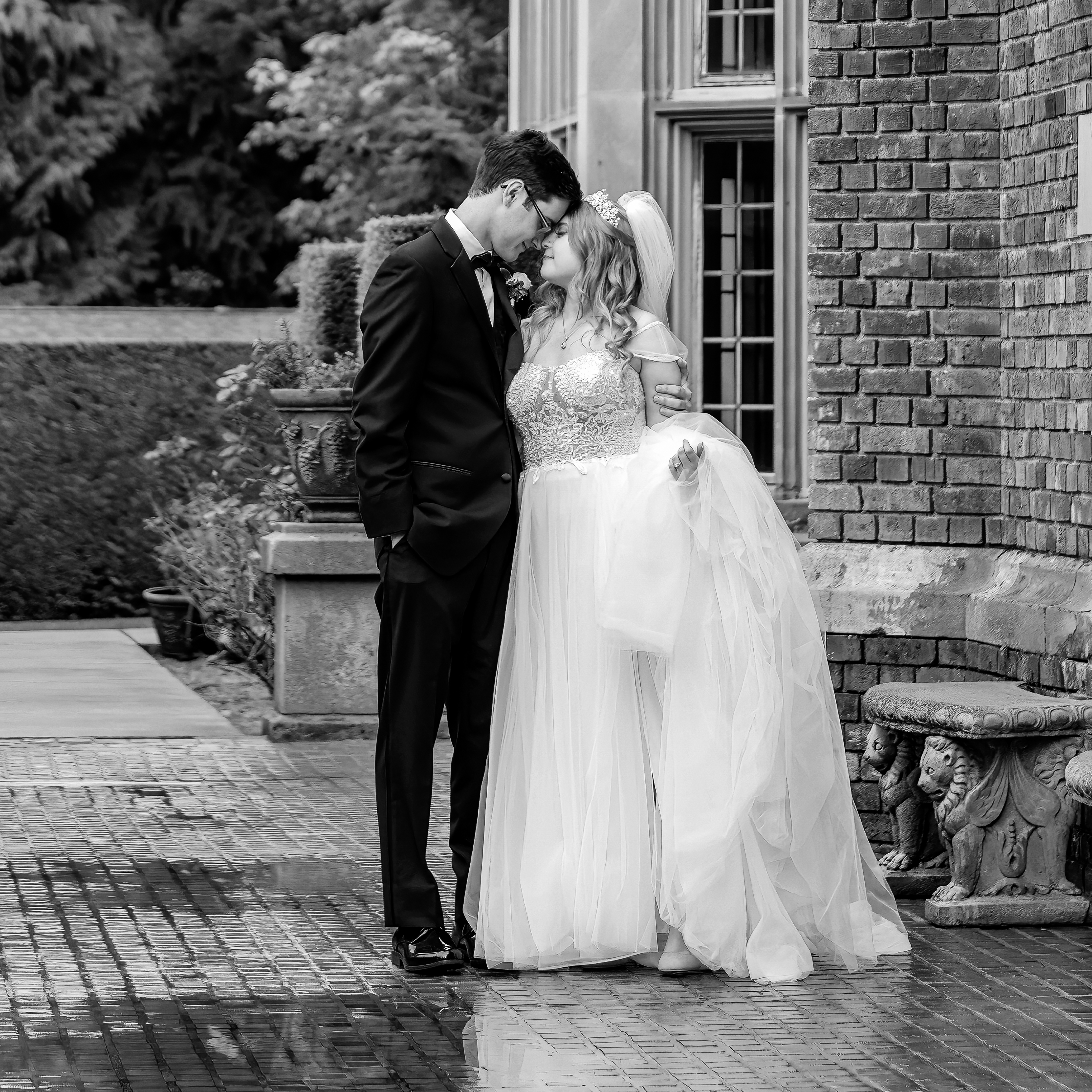 Black and white photo of wedding couple standing on the side of Thornwood Castle which is a romantic and iconic venue. 