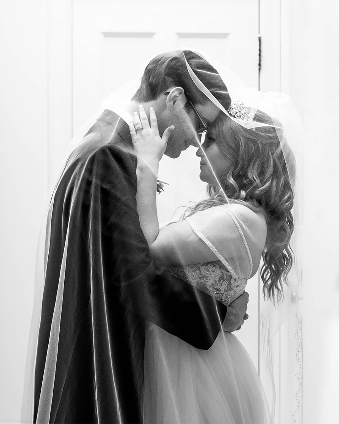 Couple standing under the veil looking at each other. 