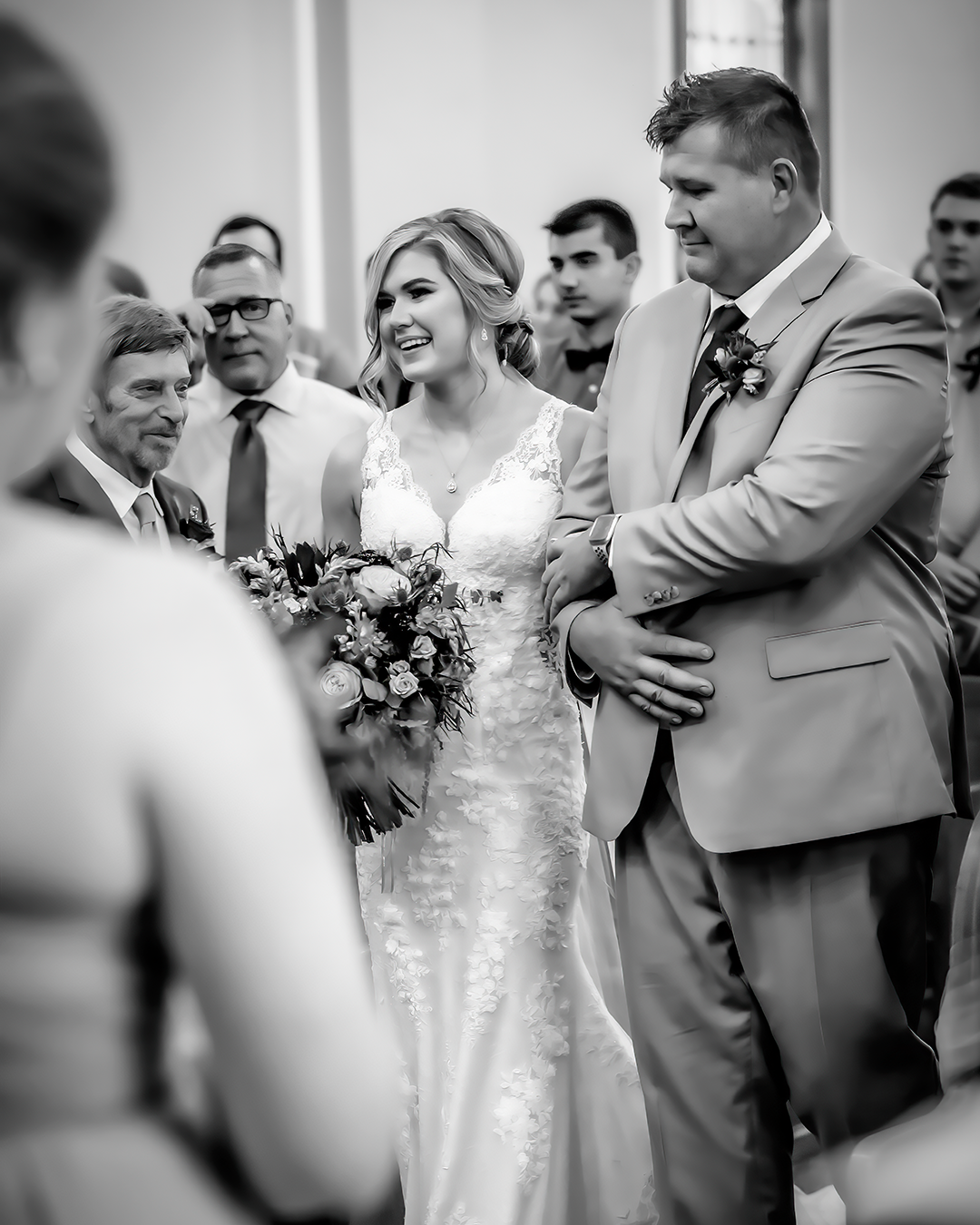 Blackand white photo of bride walking down the aisle with her dad. 