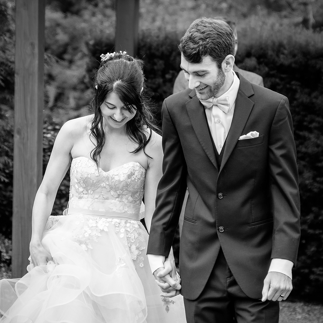A heartfelt embrace between a bride in a flowing veil and her dad in a tailored suit, set against a scenic backdrop of trees, capturing the emotional depth of her wedding..