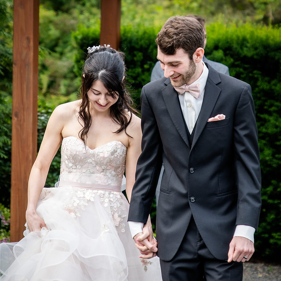 Couple looking down as they exit the ceremony on their wedding day. 