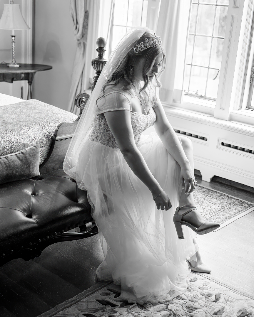 Bride putting on her shoes during a getting ready moment. 