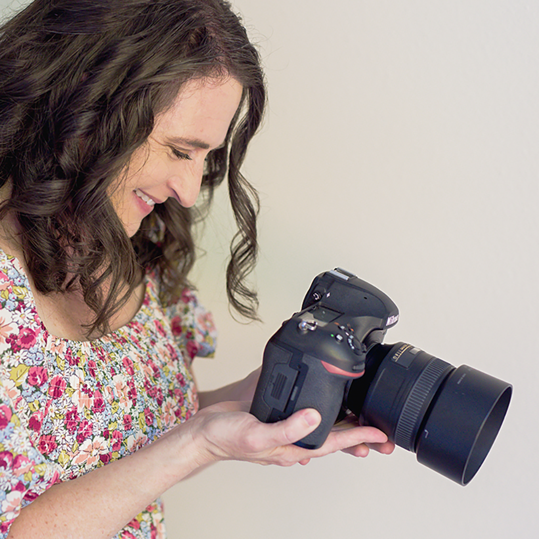 Profile picture of Adina holding her camera. 