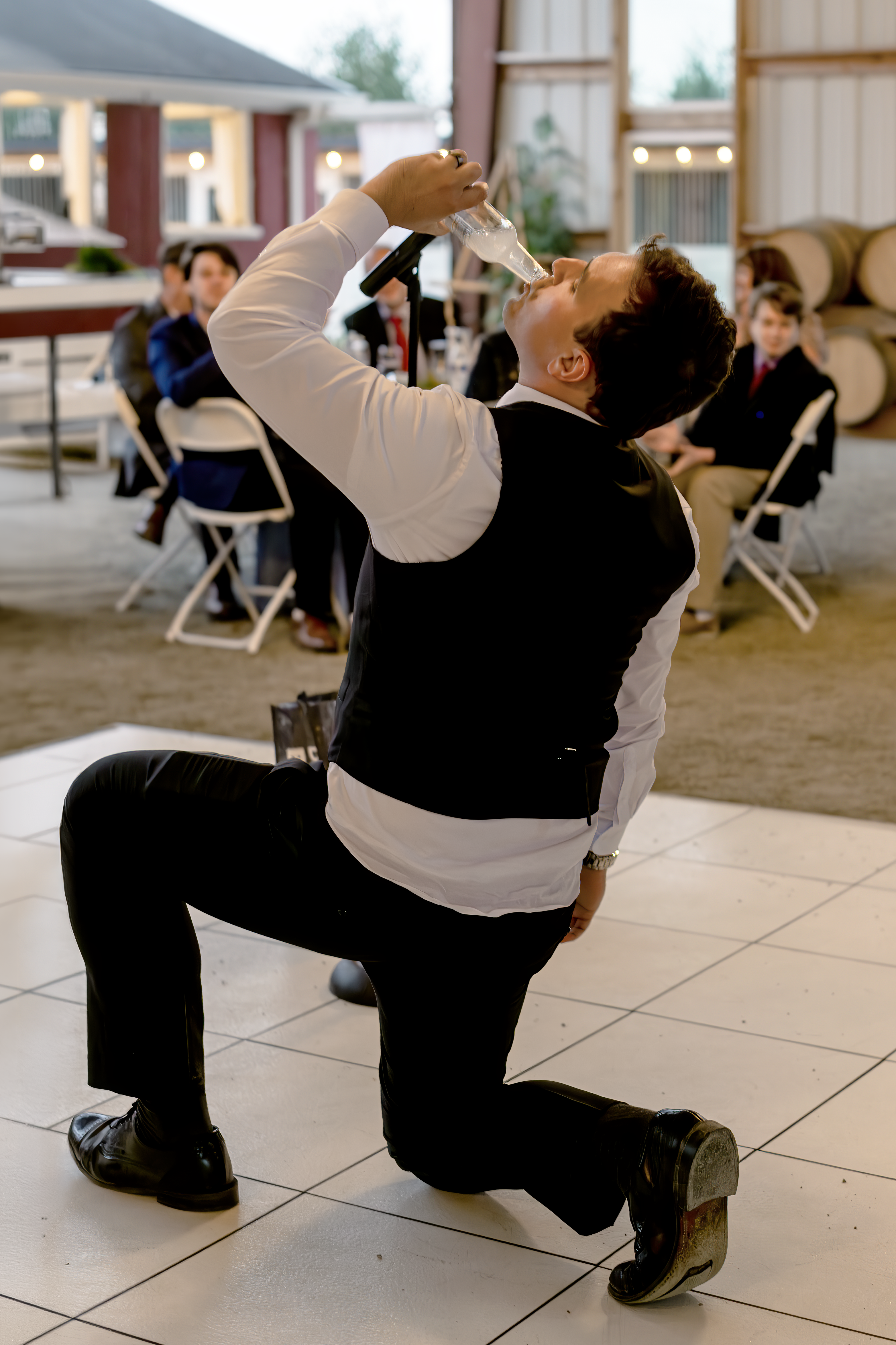 Groom drinking a Smirnoff Ice drink as part of a fun game at a wedding reception. They called it being "iced."
