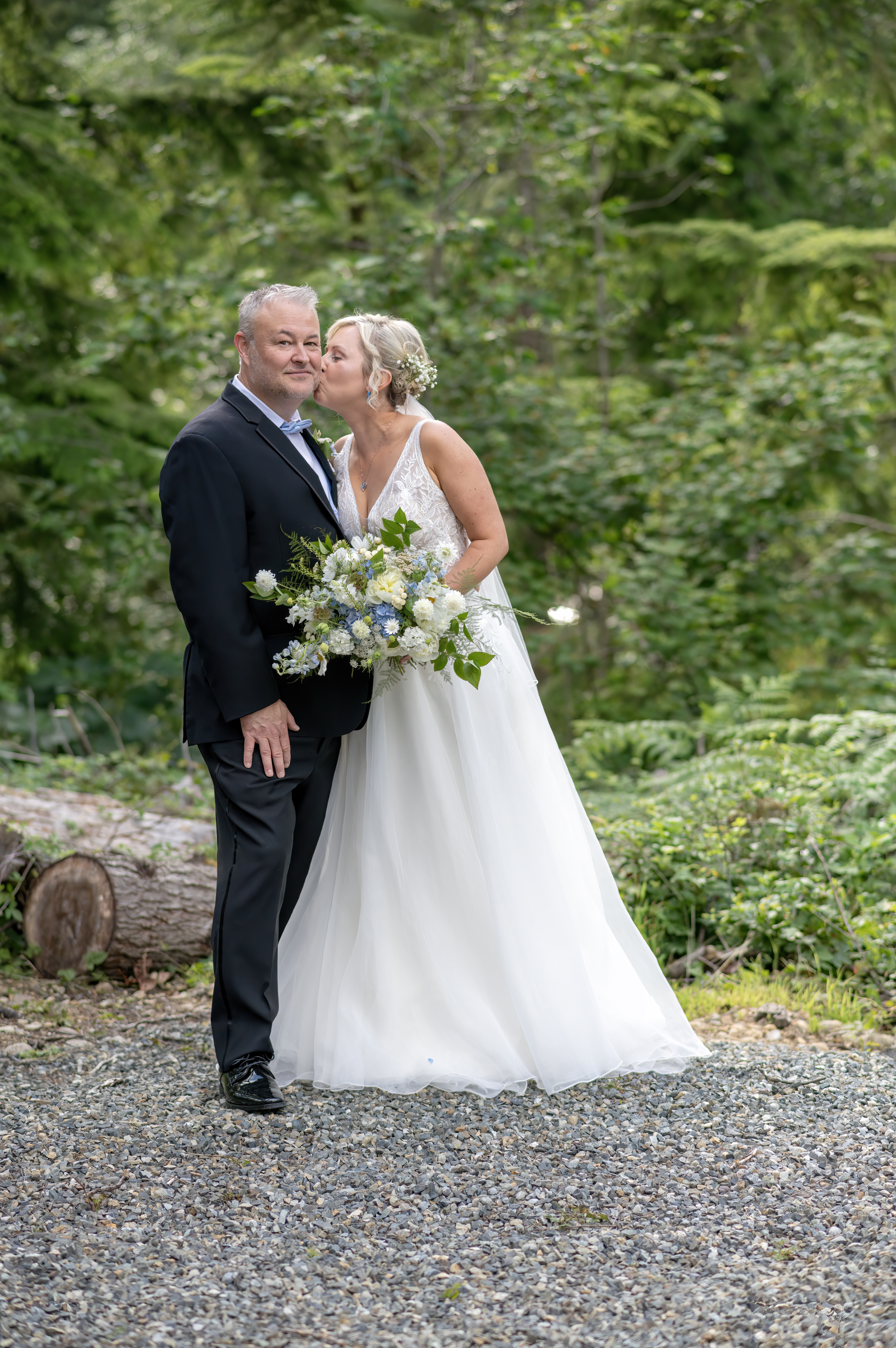 Bride kisses groom on the cheek after their ceremony. 