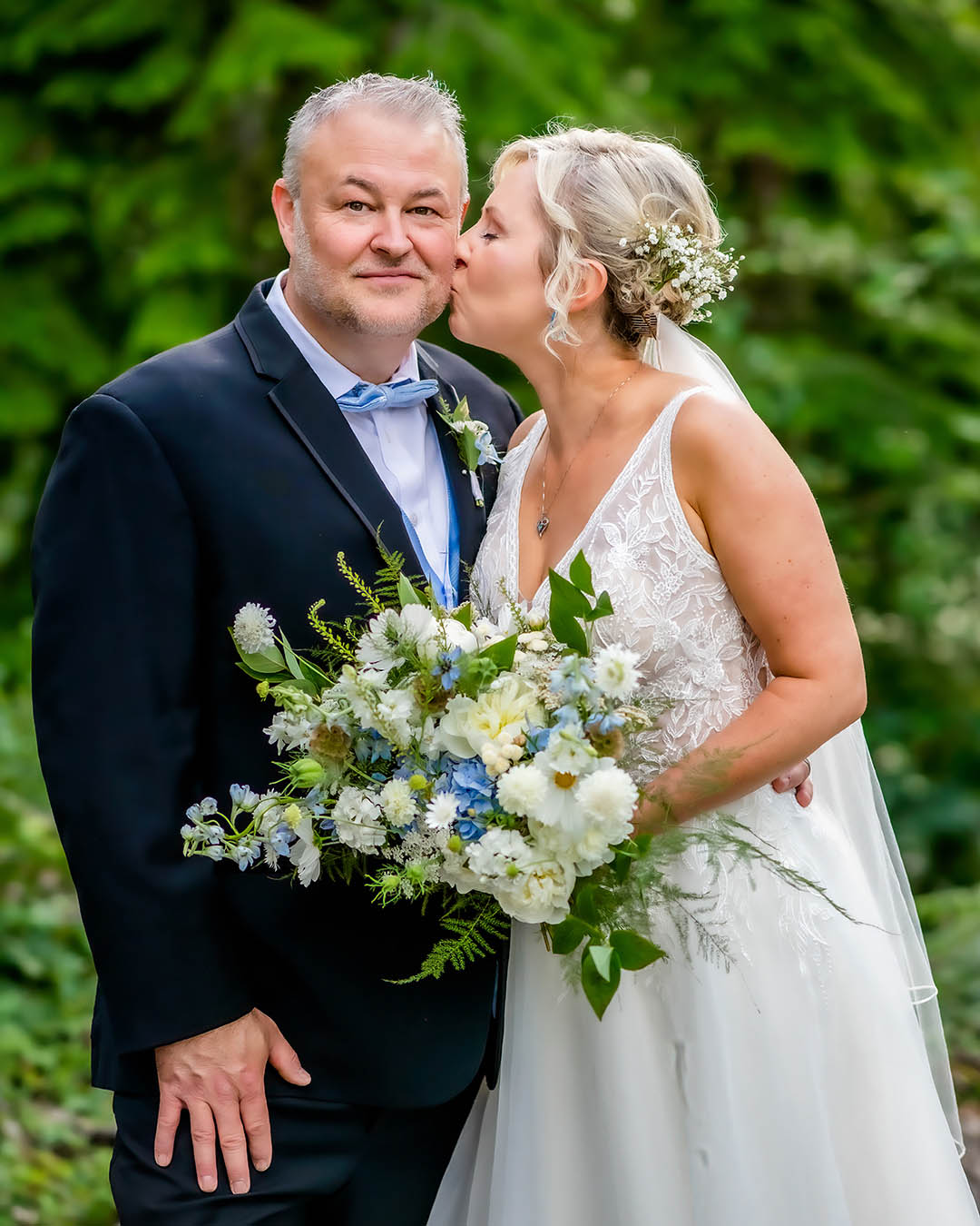 Bride kisses groom in the evergreen forest of the Sugarloaf Mountain Valley in Maple Valley.