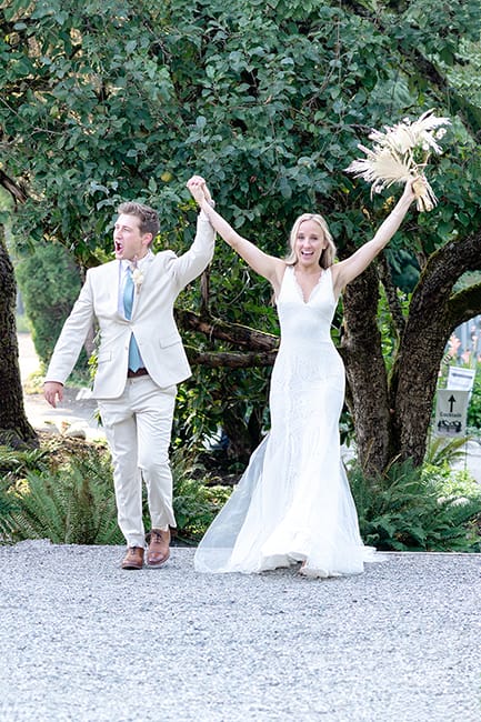 Couple cheers as they celebrate their wedding ceremony after the first kiss. 