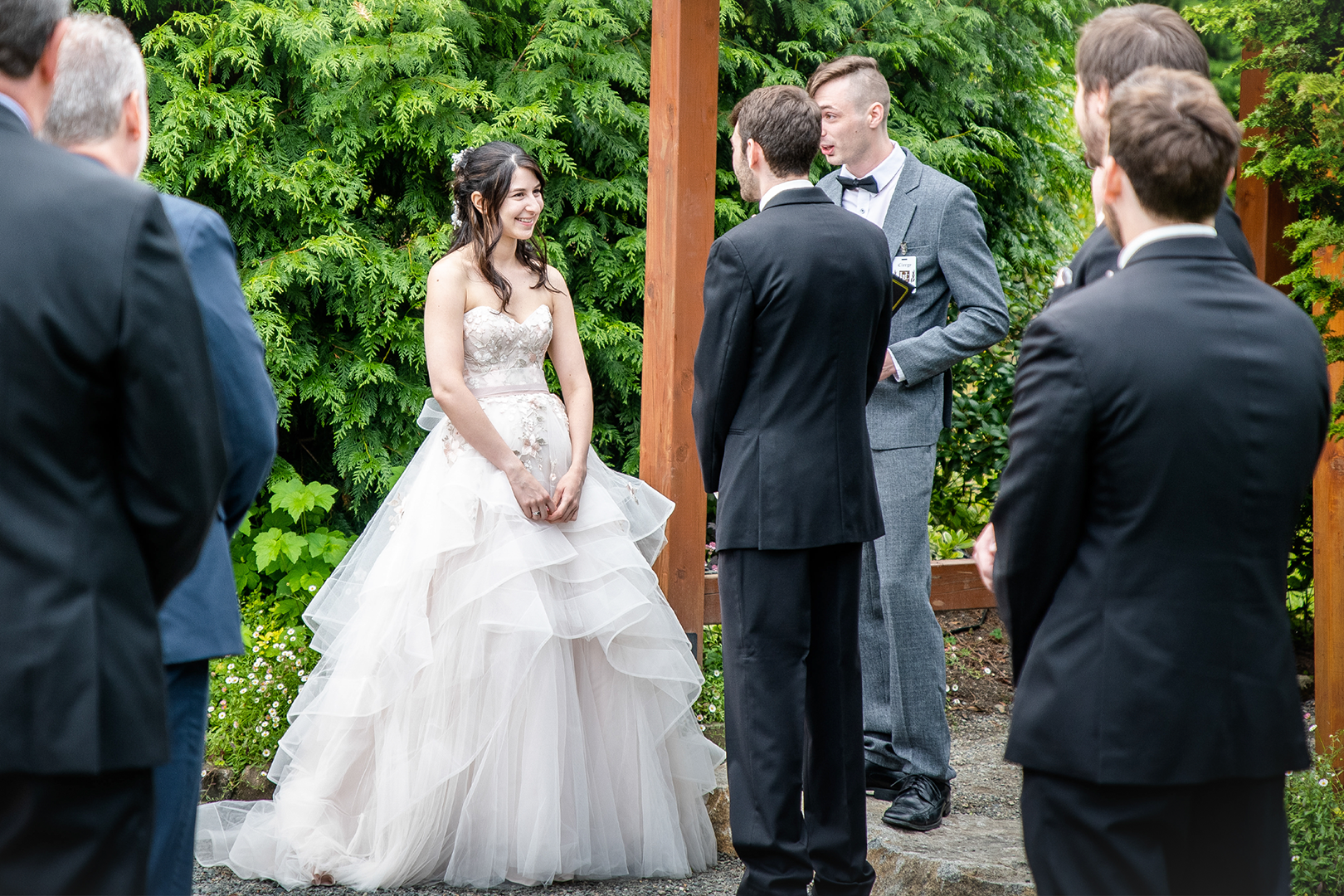 Bride and groom standing on a life-size chess board. Bride is holding a cascading bouquet while the breeze caught her cathedral length veil near Seattle. 