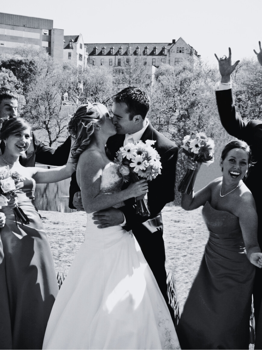 Couple walkng down the aisle after the ceremony and cheered on b their parents.