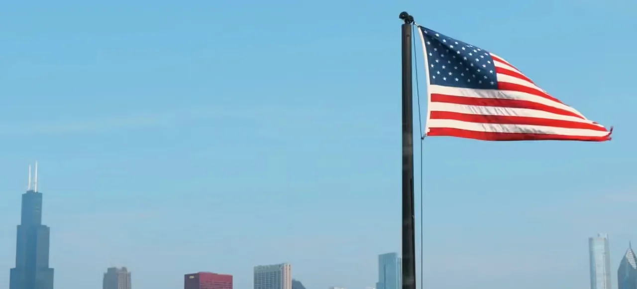 Bandeira dos Estados Unidos diante do horizonte de uma cidade