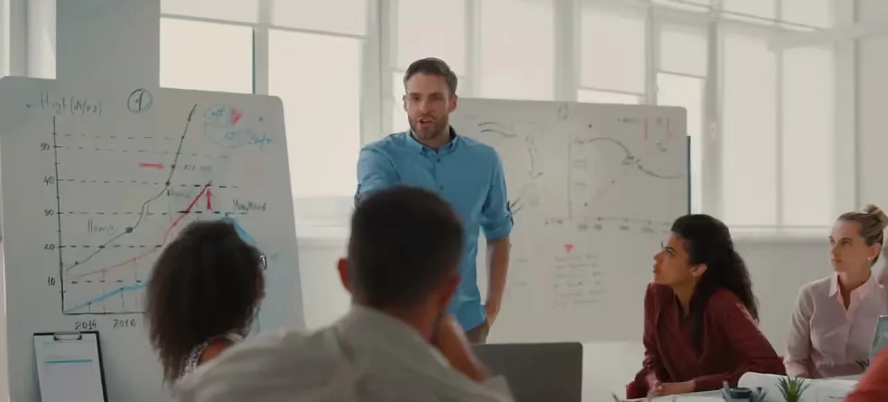 Equipe em um treinamento presencial diante de um quadro