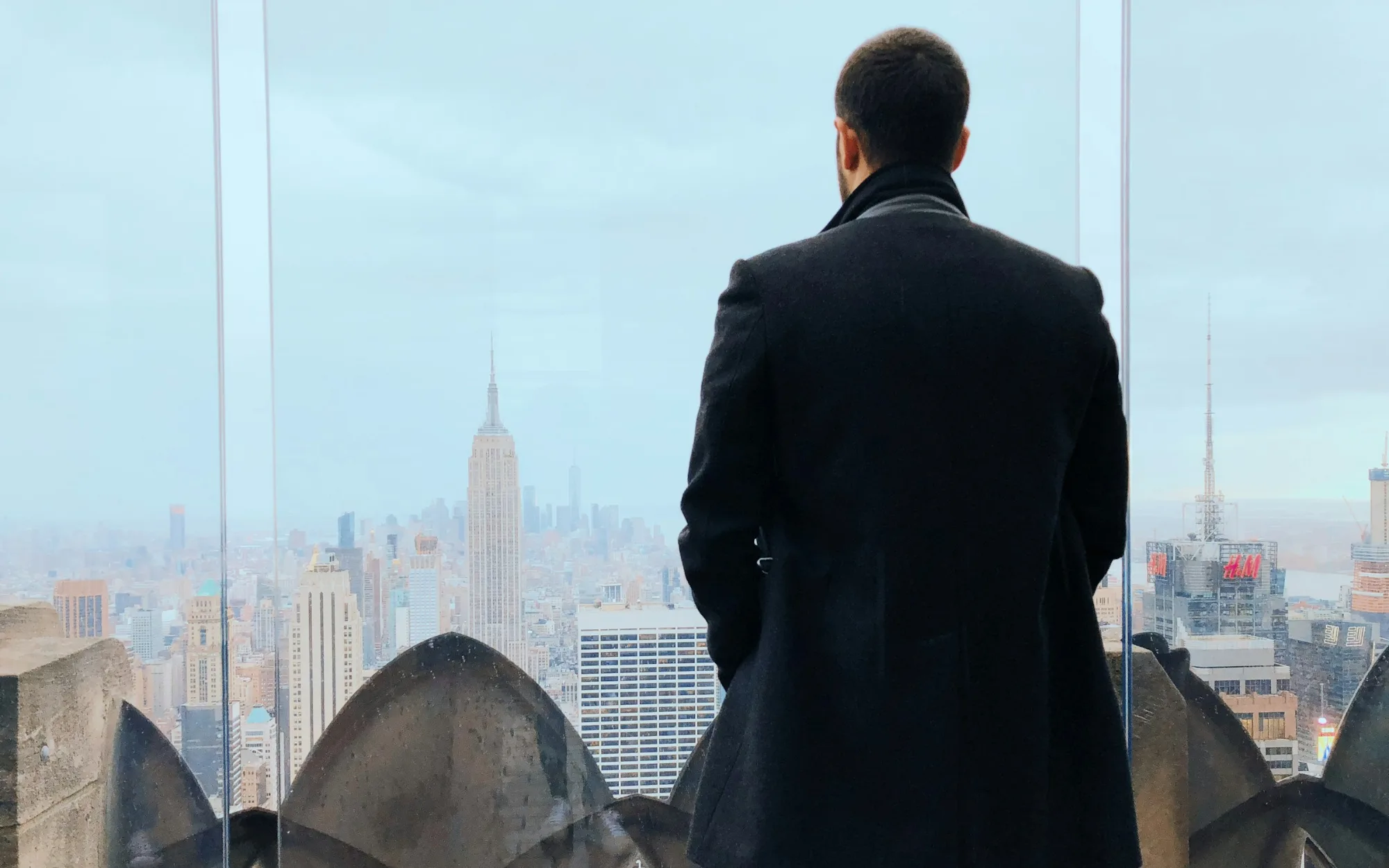 Empresário observa a cidade do alto de um prédio