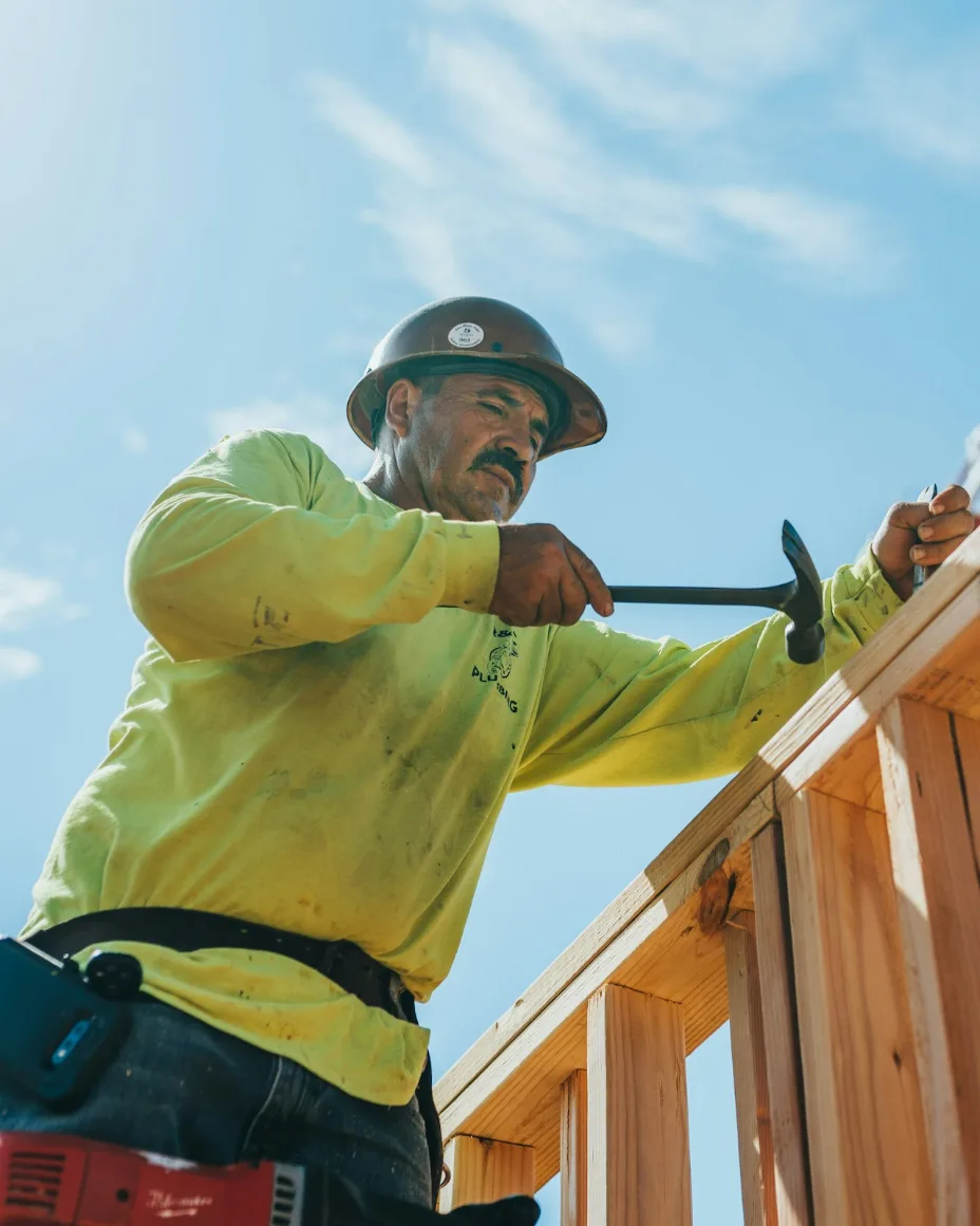 Profissional da construção trabalhando na estrutura de madeira de uma casa