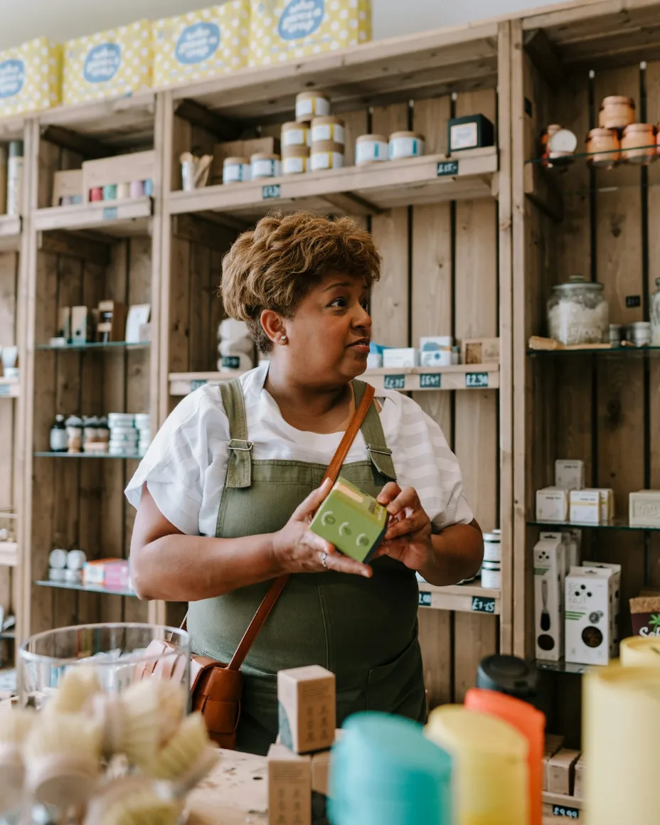 Empresária em sua loja, com produtos nas prateleiras