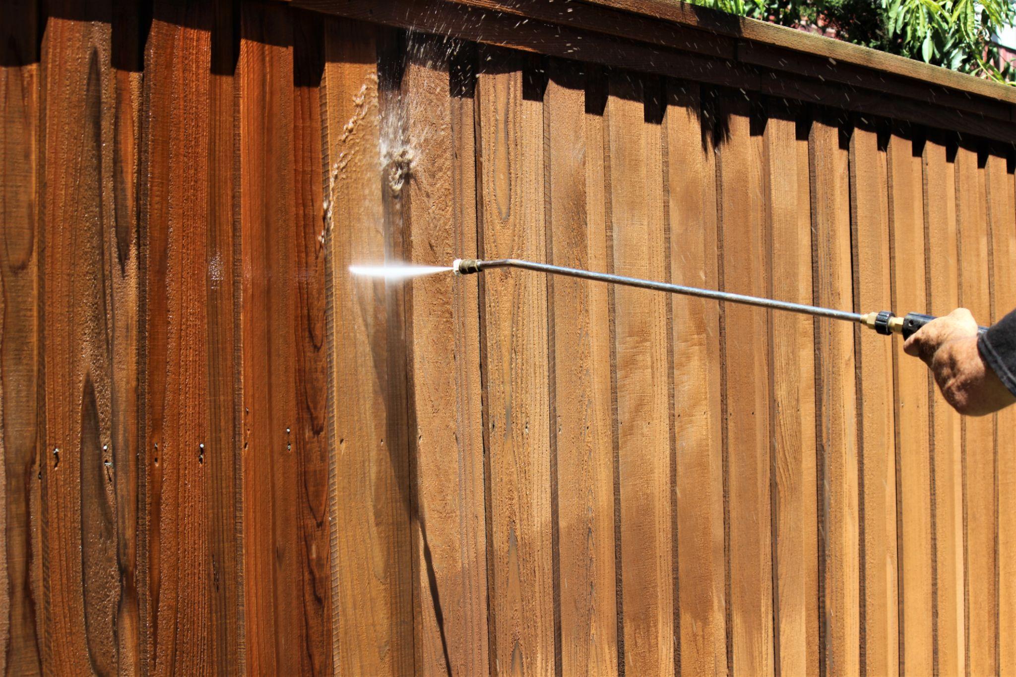 Pressure washing wooden fence before staining in Oklahoma City