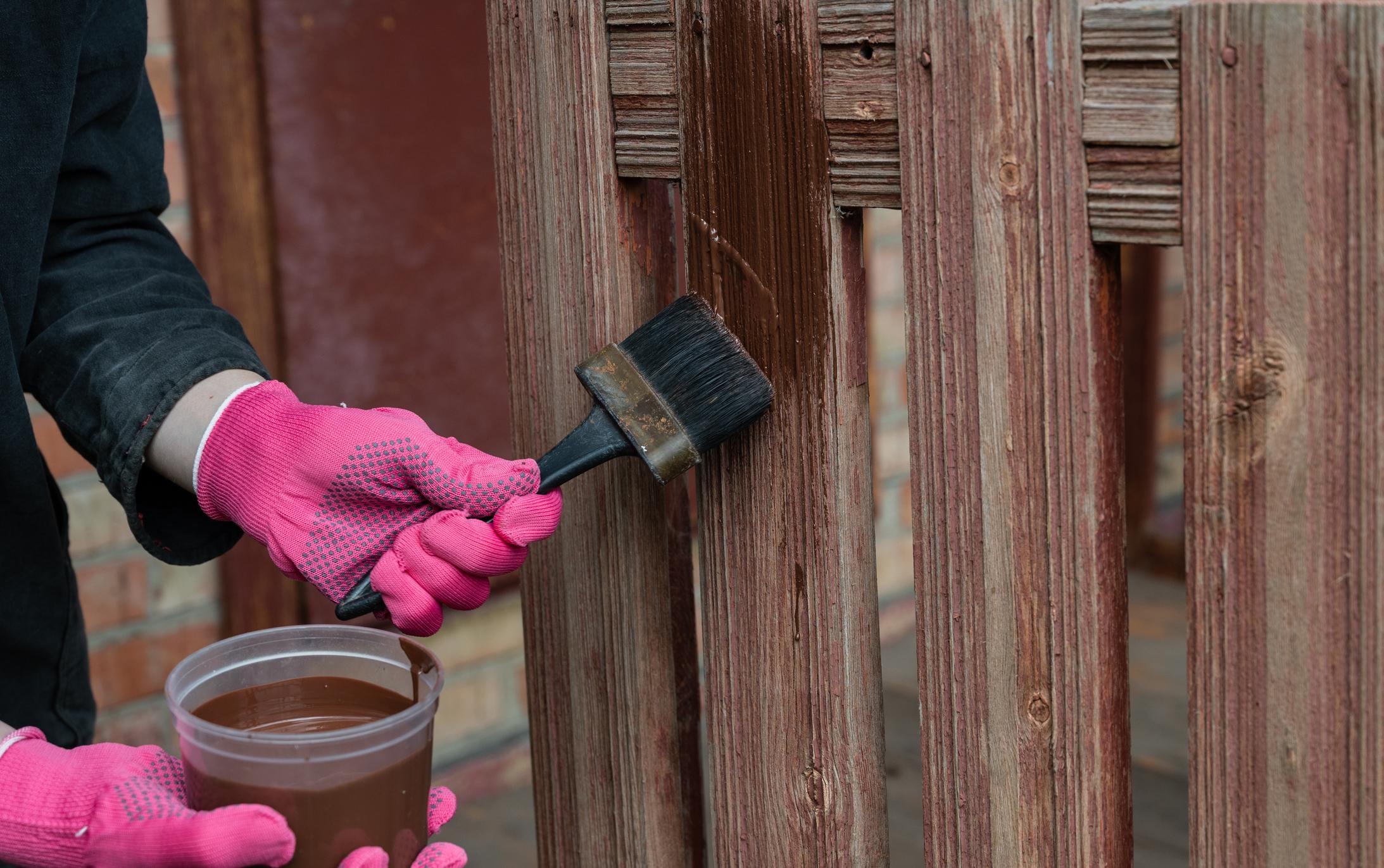 Contractor applying stain to wooden fence in Oklahoma City