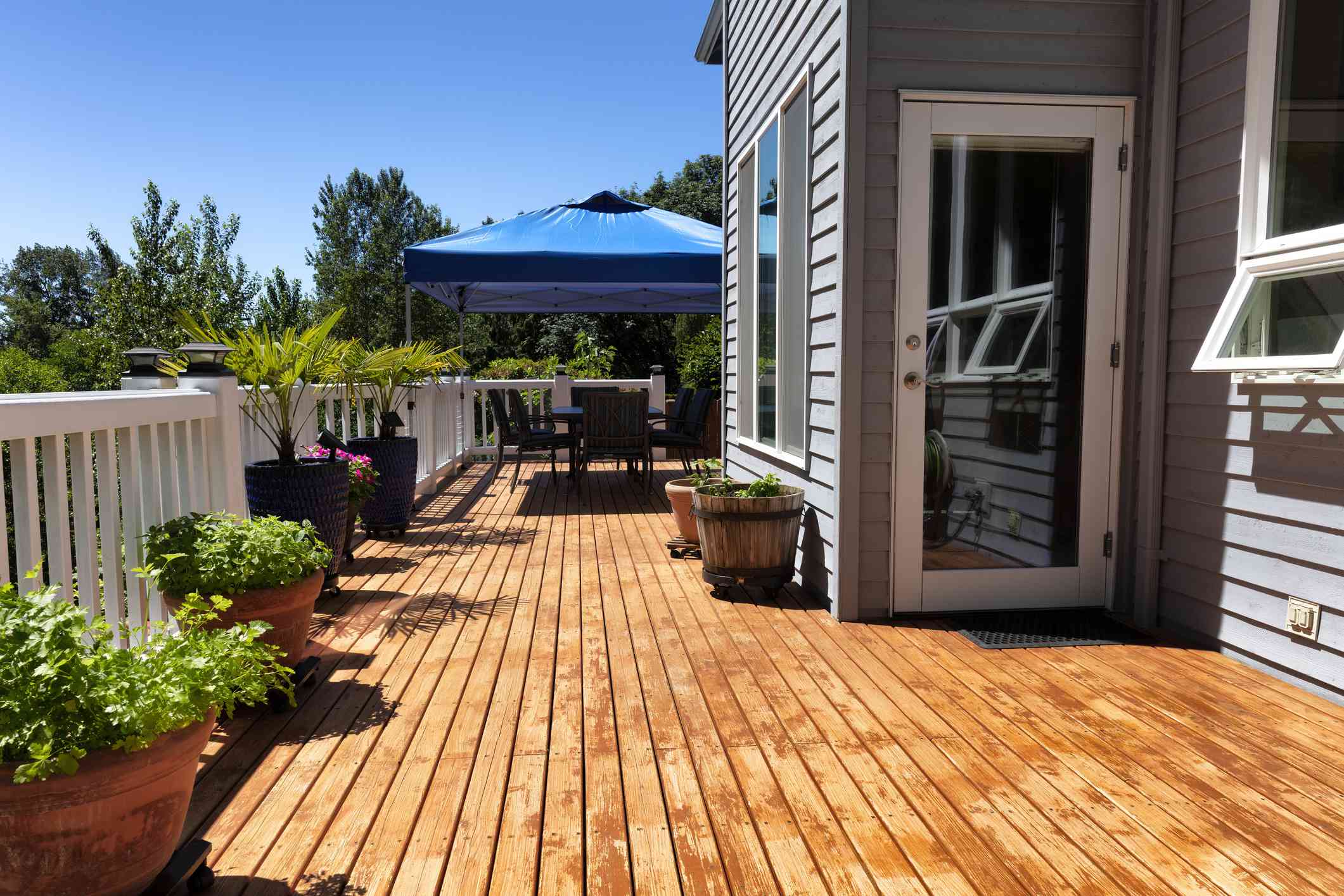 Weathered wooden deck showing UV damage, fading, and cracking from Oklahoma weather