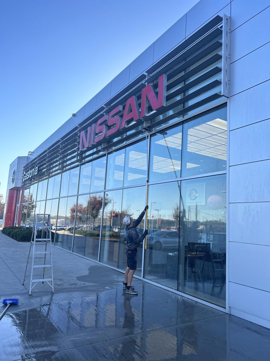 Gates crew cleaning Alucobond facade and glass at Nissan of Gastonia