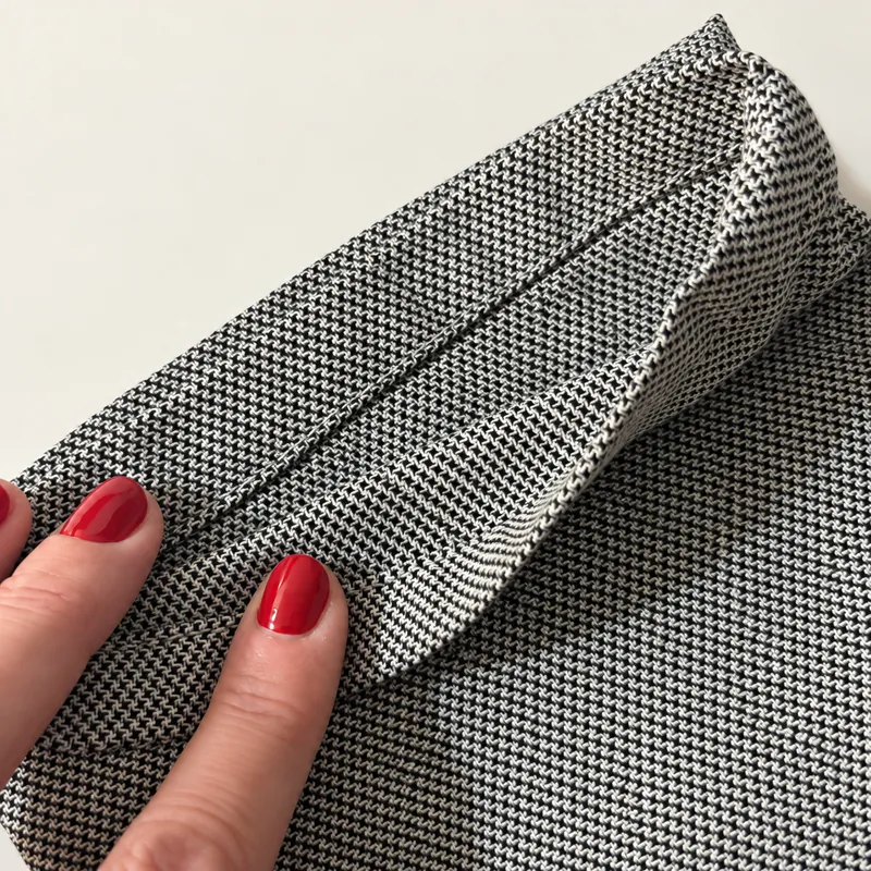 Bajo de un pantalón de tela doblado y cosido con un dobladillo sencillo