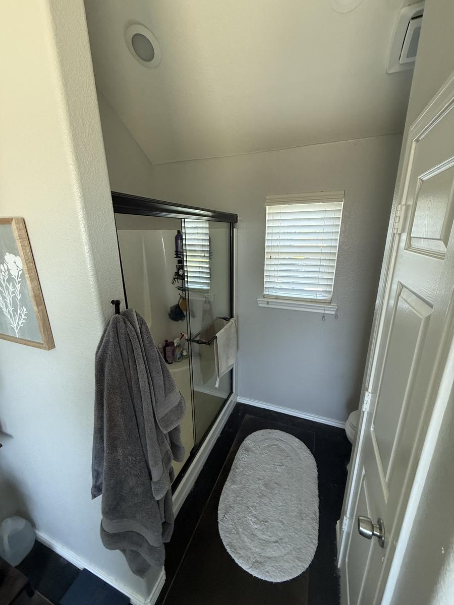 Older shower behind sliding glass doors