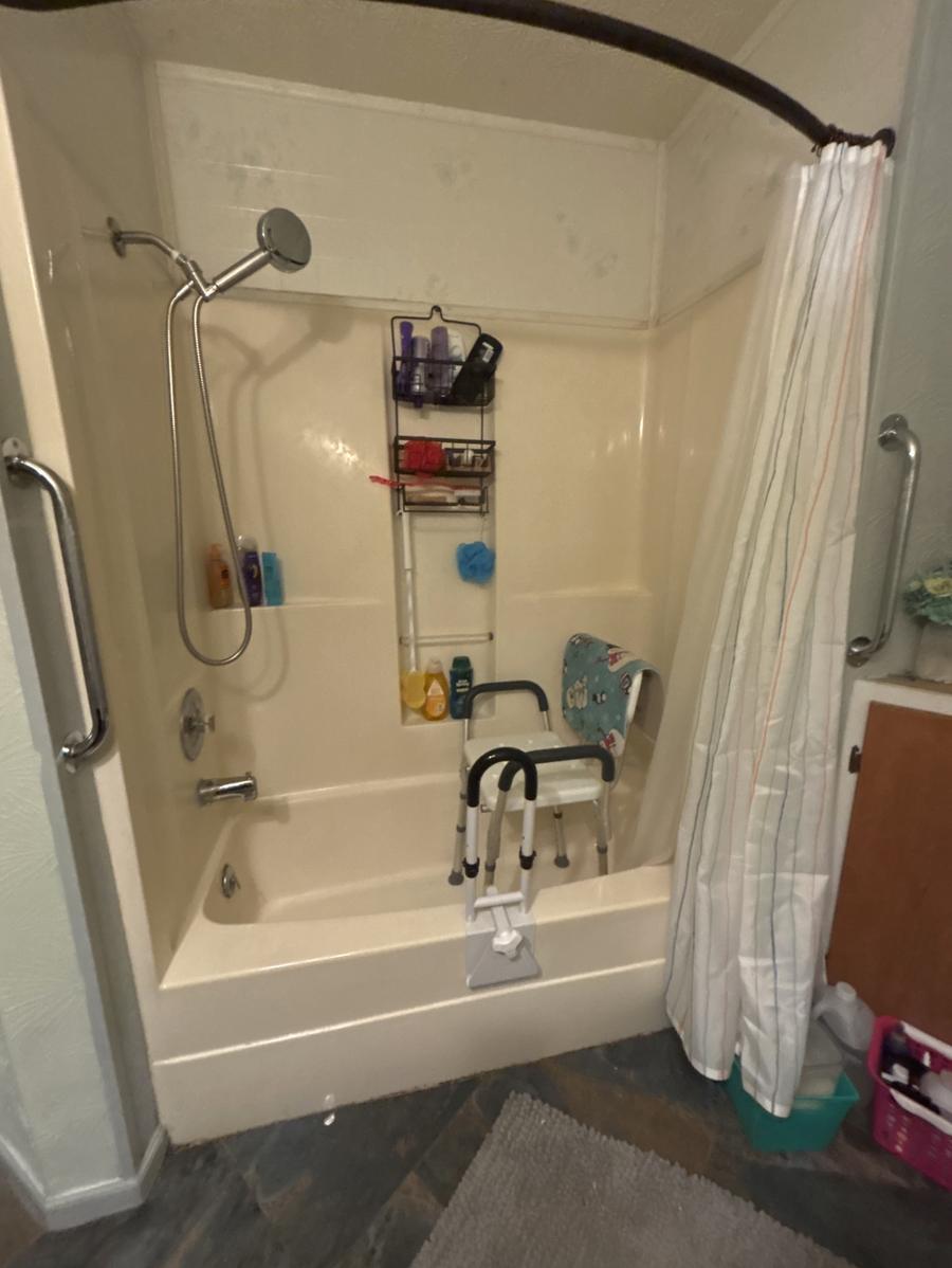 Bathtub with a shower chair and tub transfer rail inside