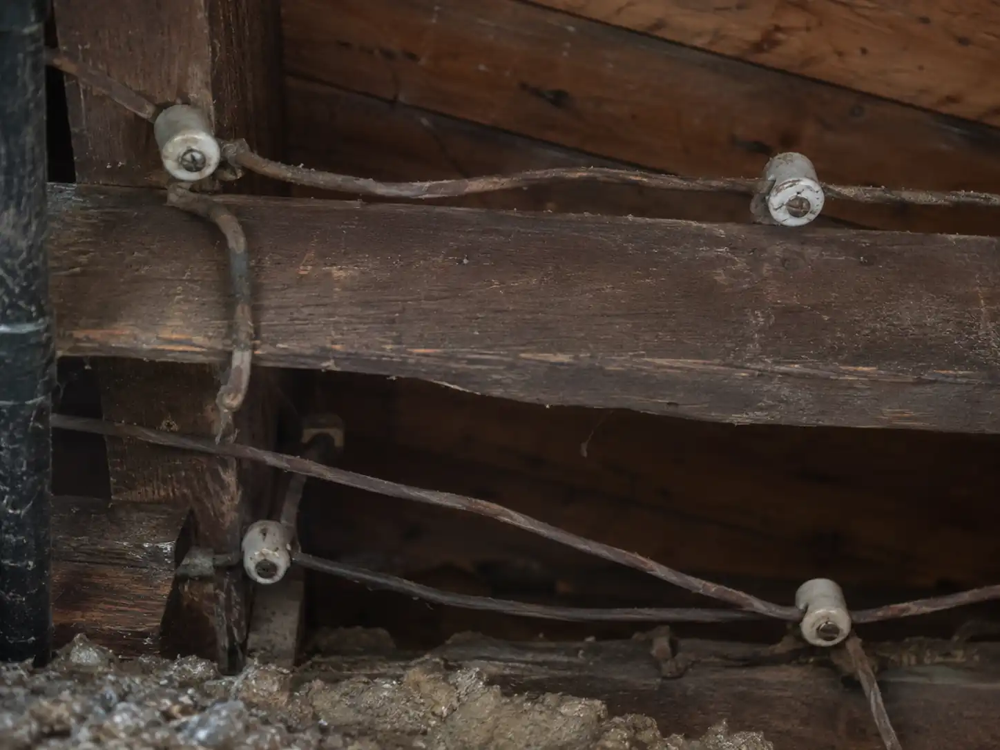 Exposed knob-and-tube wiring on ceramic insulators between wood framing in an old Shaker Heights attic