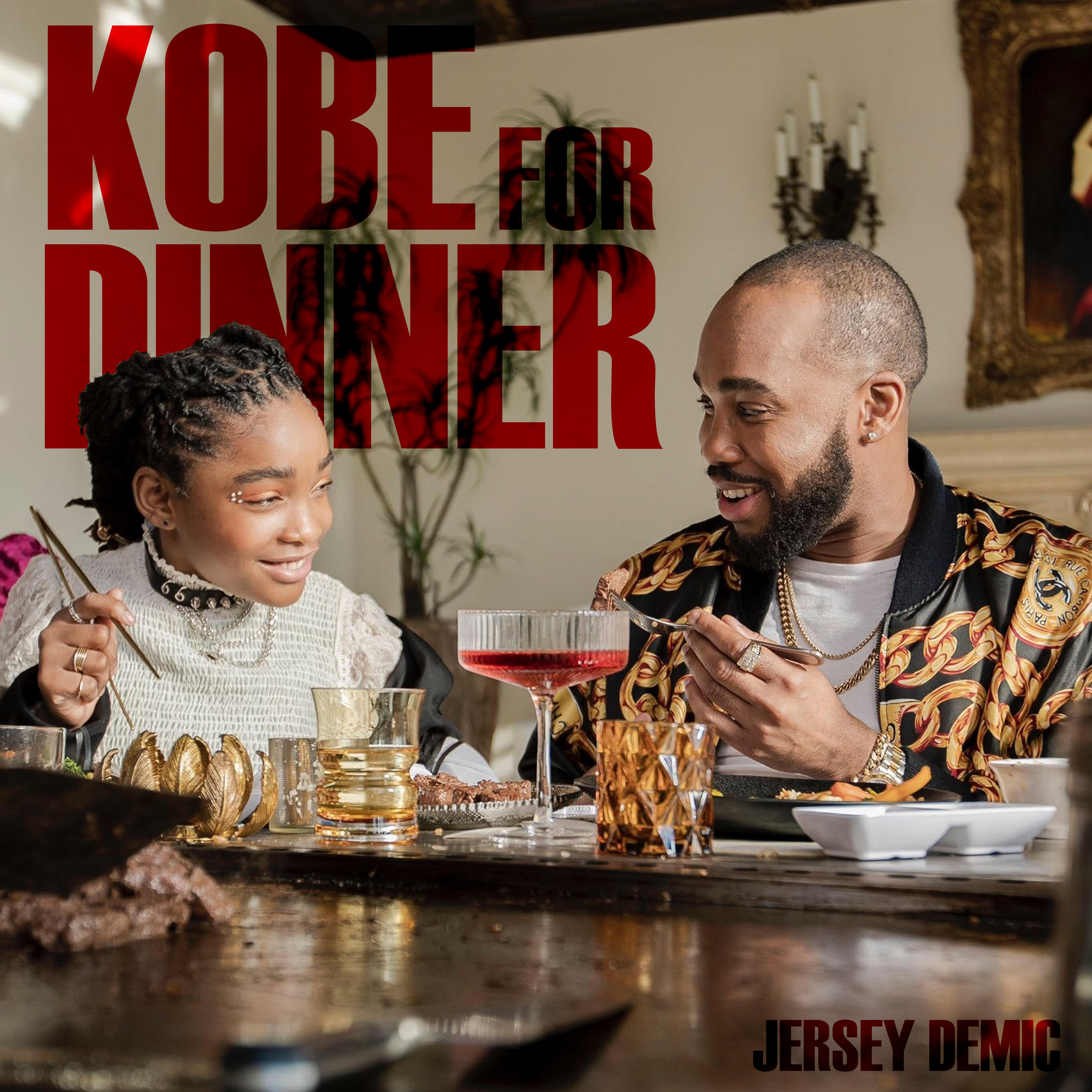 Kobe for Dinner album cover featuring a young girl and a man enjoying a meal together, with elegant dishes and drinks on a lavish table, emphasizing creativity and connection in the context of music and video content by Danny Adivo.