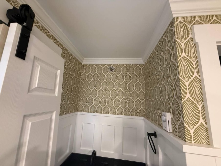 Finished patterned wall treatment with detailed trim and wainscoting