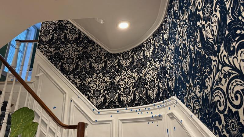 Decorative wallpaper installation along a finished staircase