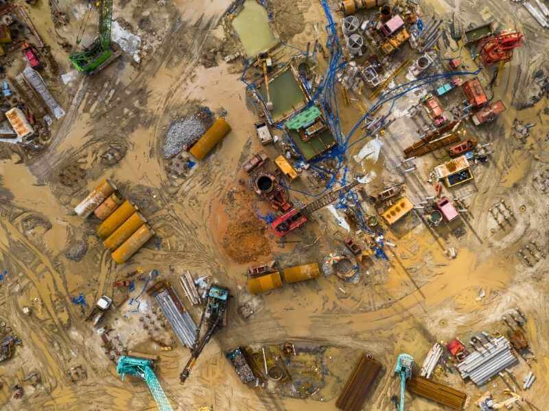 Aerial view of an active construction site showing earthwork, heavy equipment, and ground conditions captured from above. Aerial view of an active construction site showing earthwork, heavy equipment, and ground conditions captured from above.