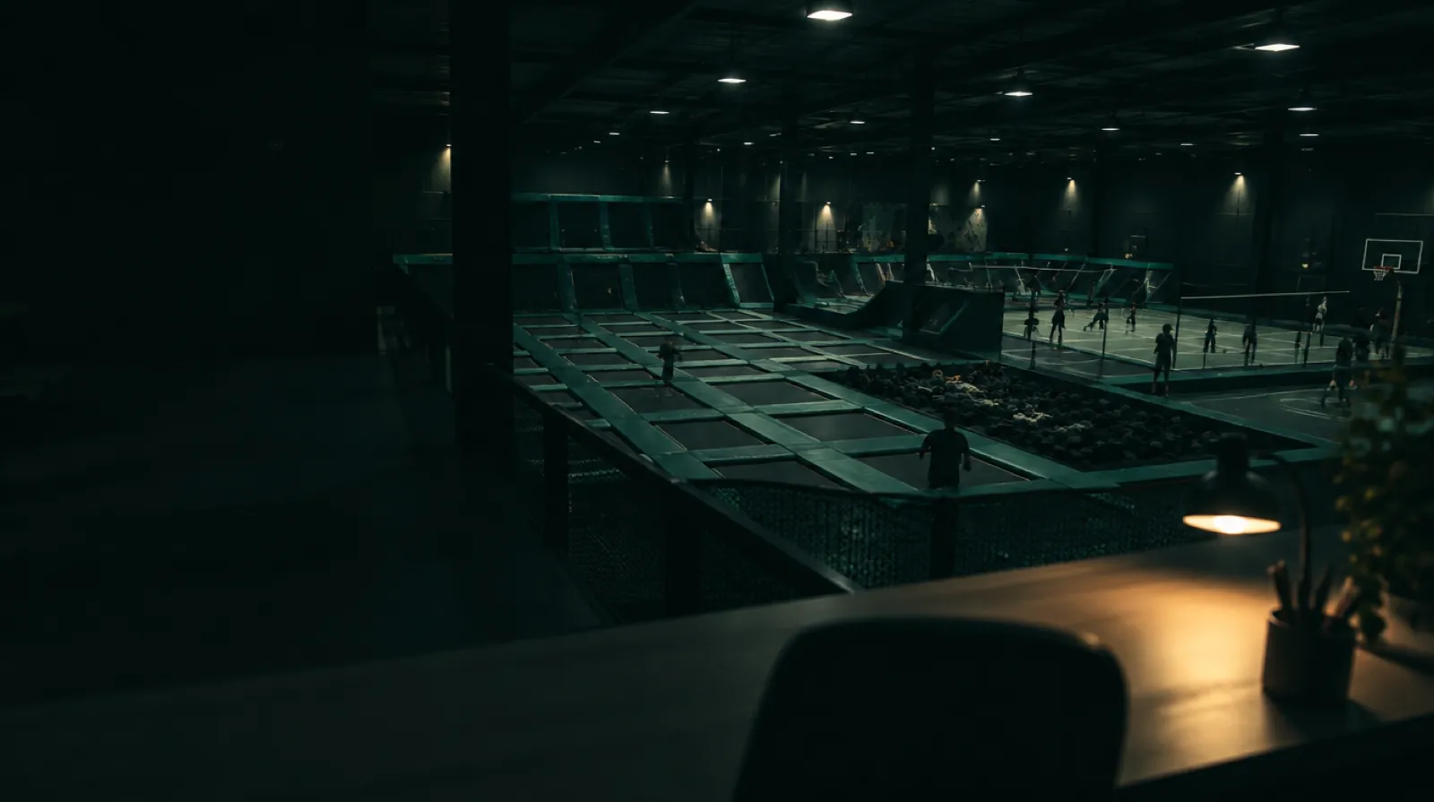 A wide view of an indoor leisure venue floor mid-session, from the operator's side of the desk