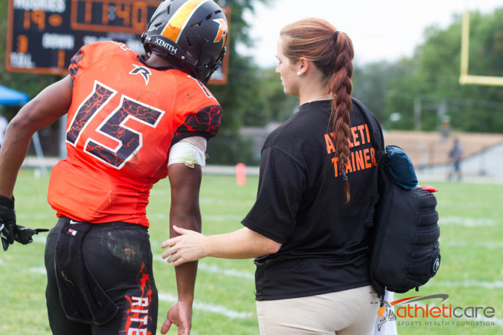 Athletic trainer evaluating an athlete