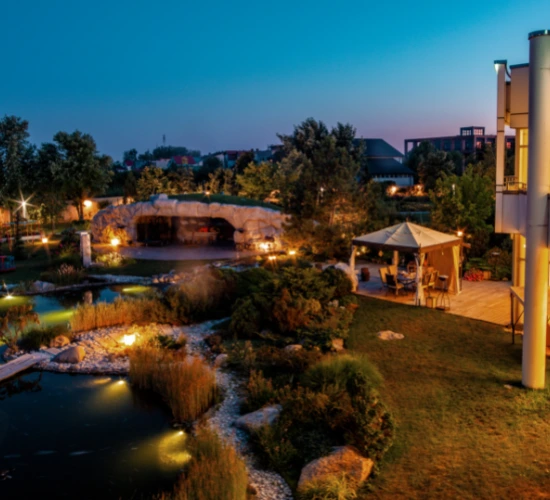 backyard of Luxurious Mansion with Small Fish Pond and Patio Area in Summer Twilight