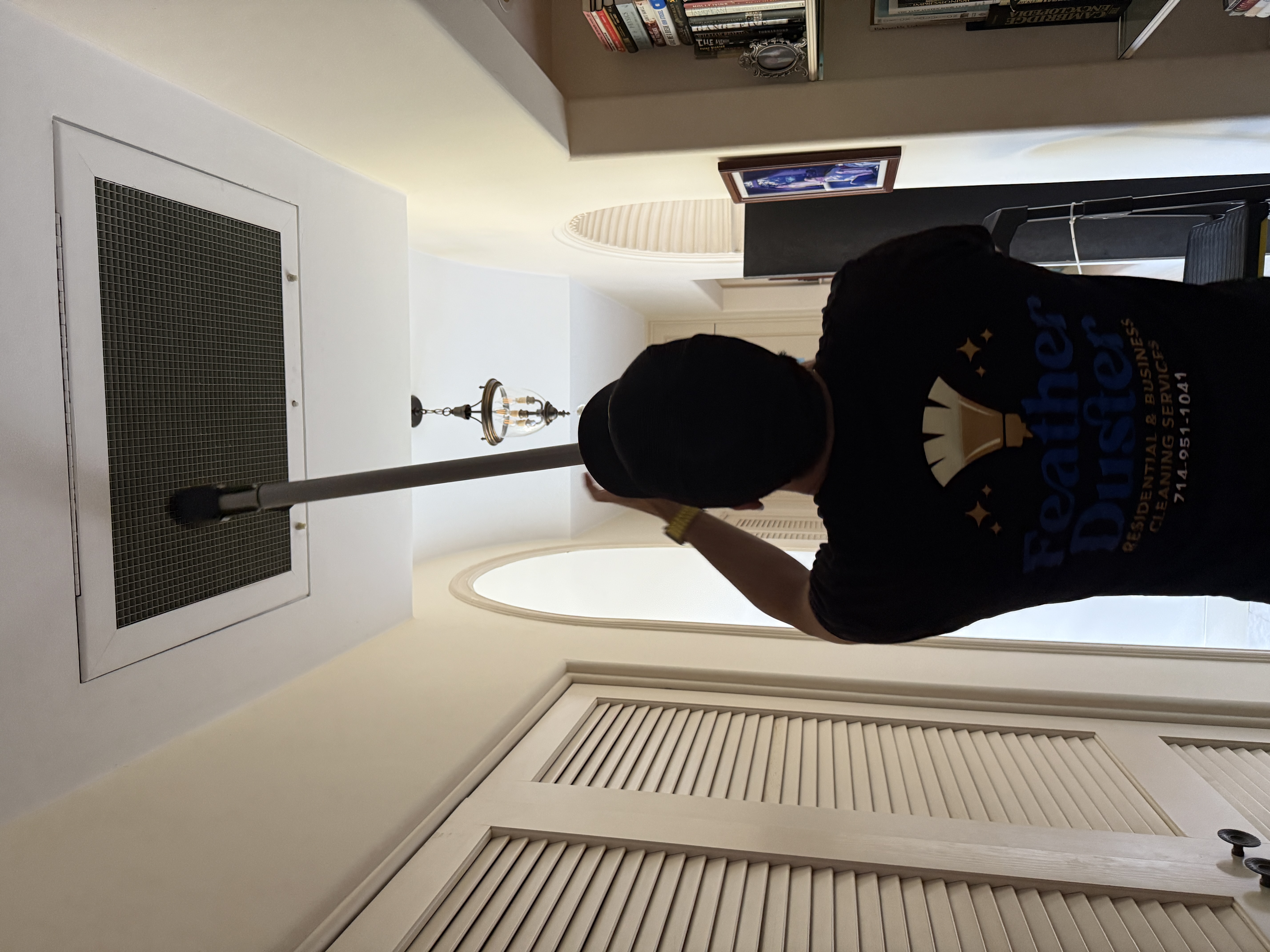 Feather Duster team member detailing a ceiling air-return vent