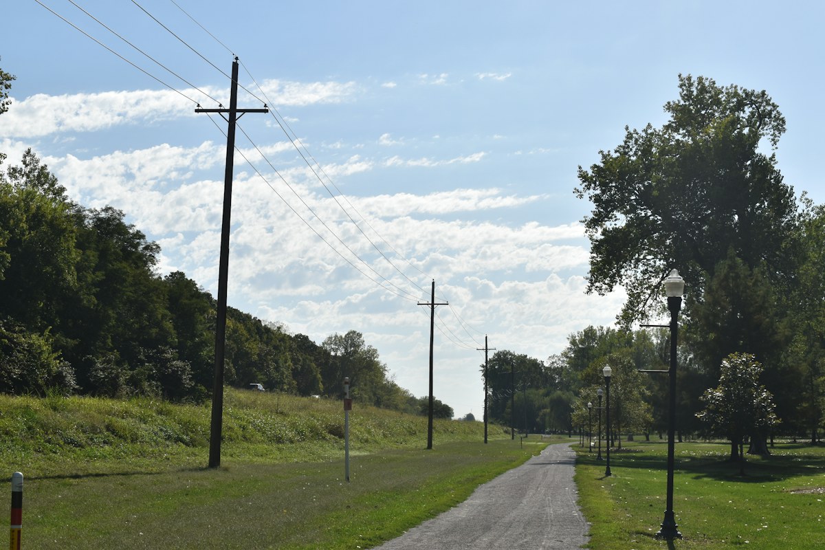 Rural road with utility poles, illustrating utility and service-access questions before buying a private-road home.