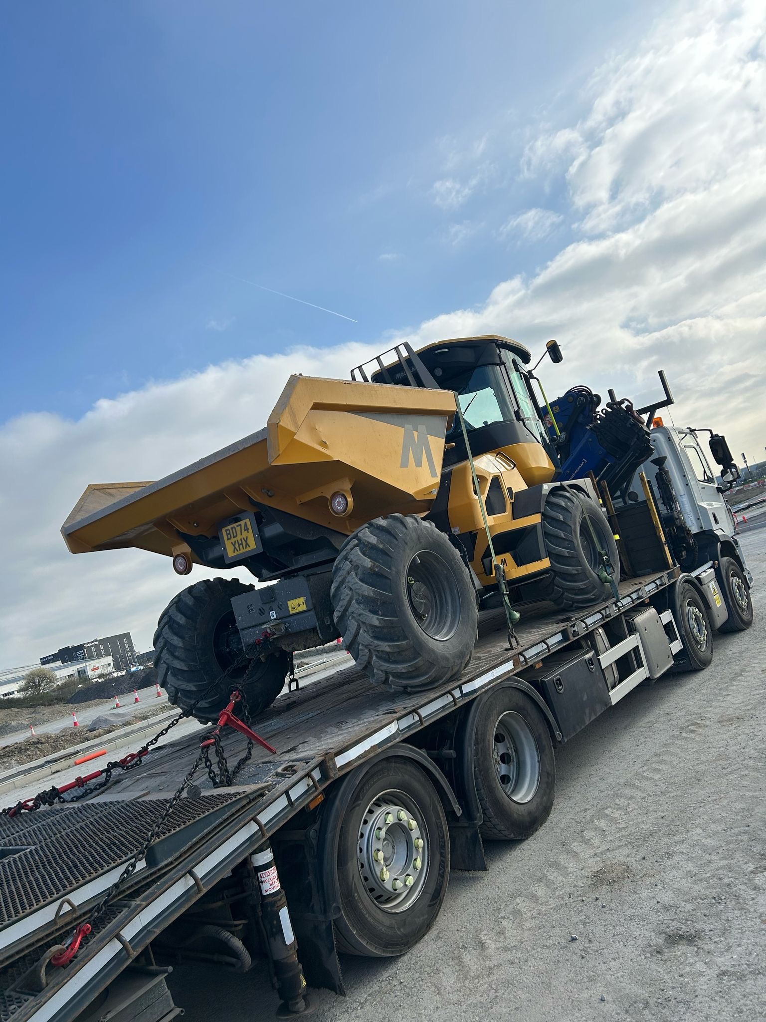 Dump truck loaded for machinery transport