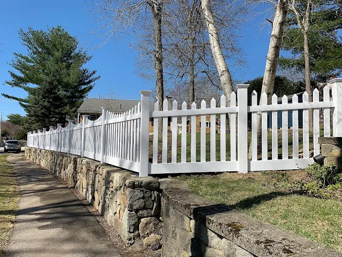 White Vinyl Picket Fence on Stone Wall
