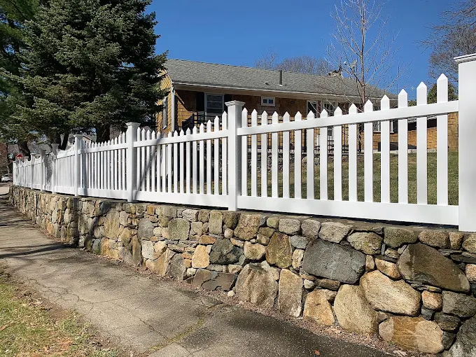 White Vinyl Picket Fence on Stone Wall