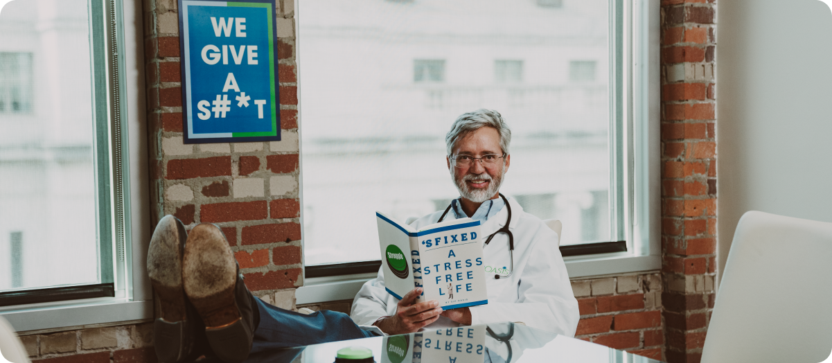Smiling business owner standing in an office near a computer workstation