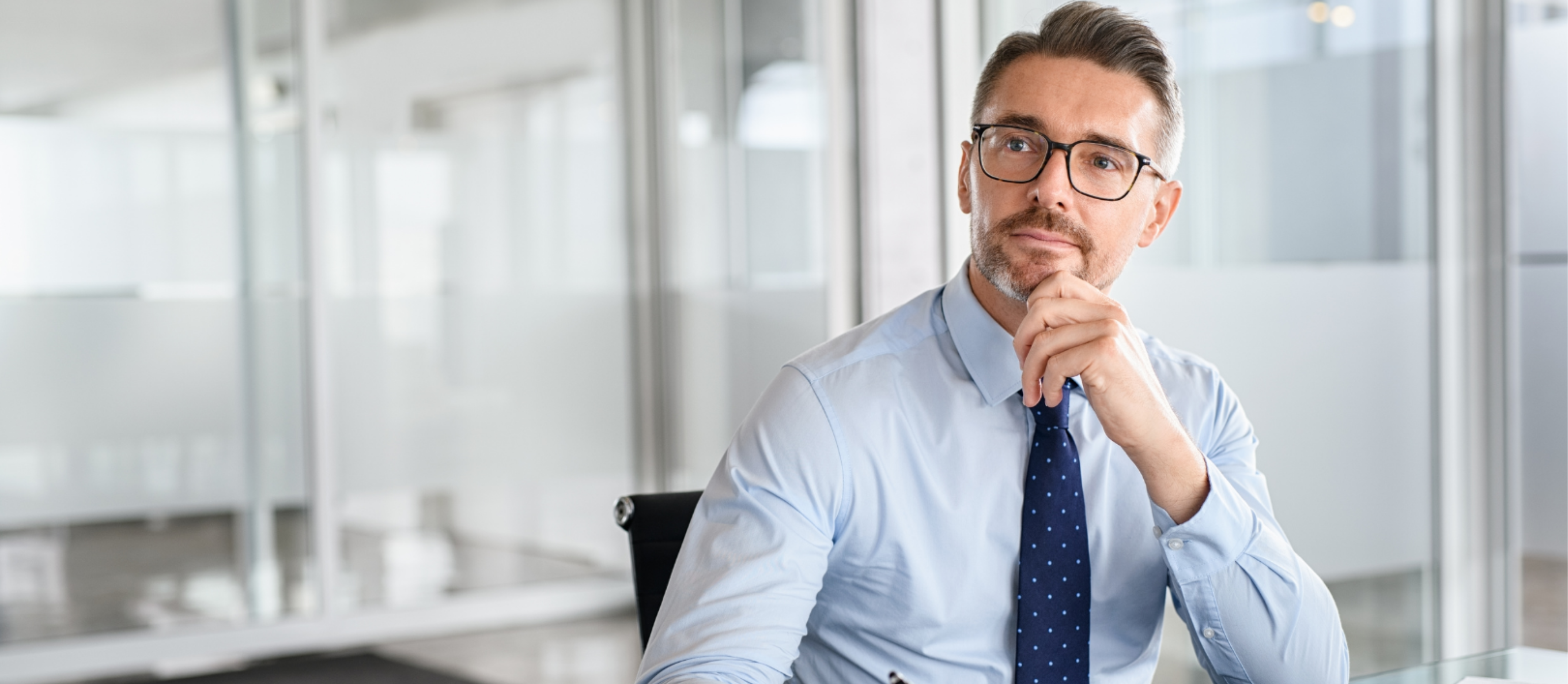Thoughtful business professional outdoors holding documents and looking concerned