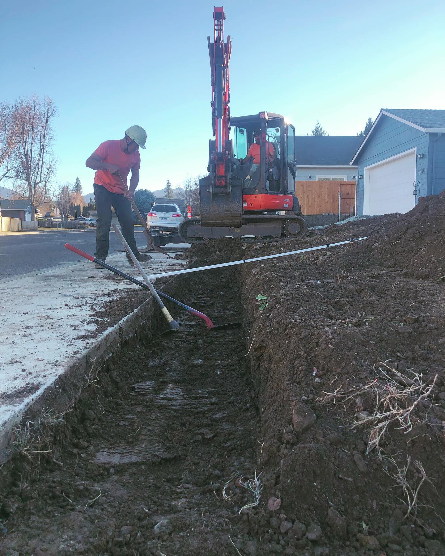 An exavator digging a trench for a retaining wall in Medford, Oregon.
