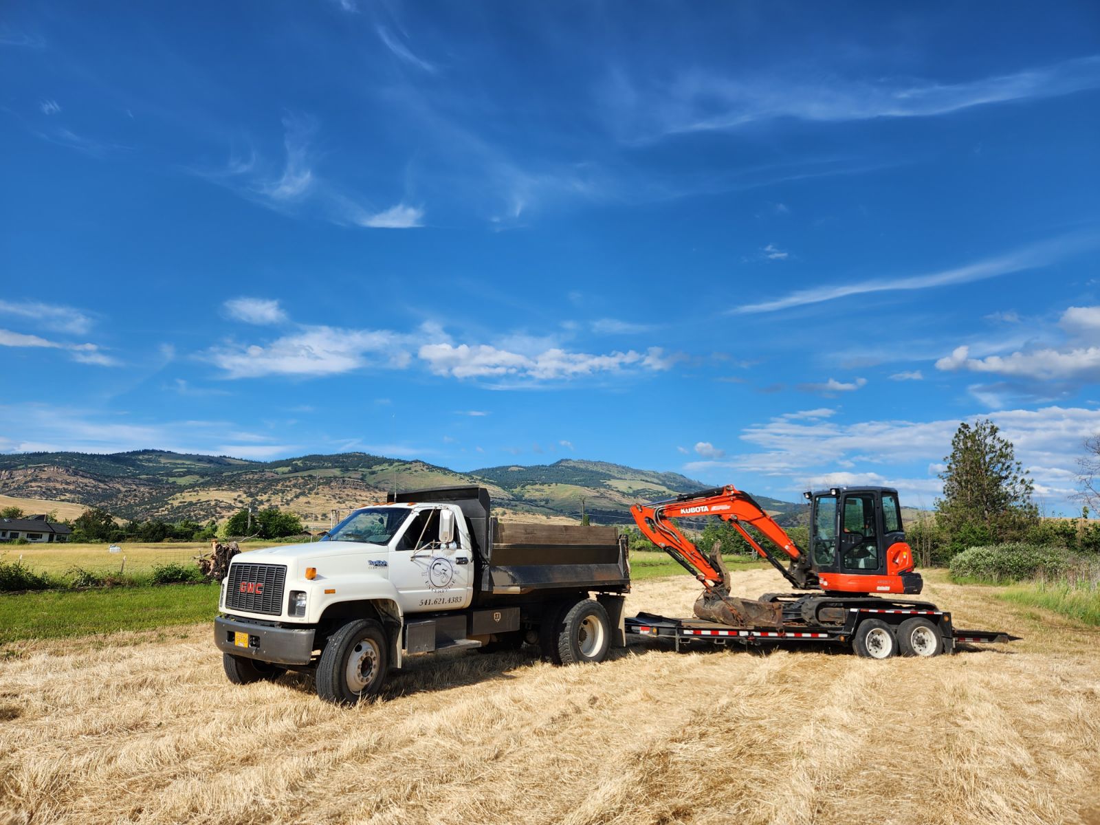A 5-yard dump truck towing an excavator in Phoenix, Oregon