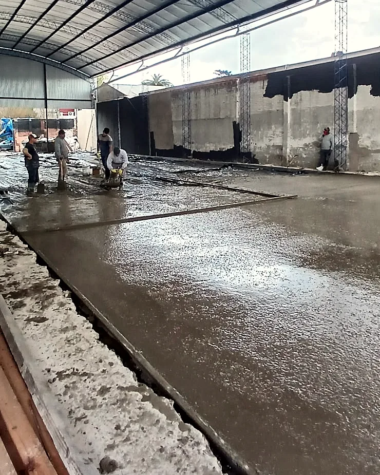 Film sobre la base, frente de hormigonado y cuadrilla trabajando bajo la cubierta.