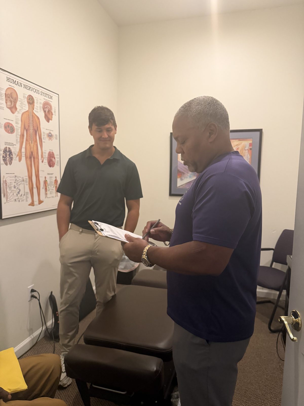 Dr. Michael Gerdine taking notes during a new patient evaluation at West End Chiropractic in St. Louis