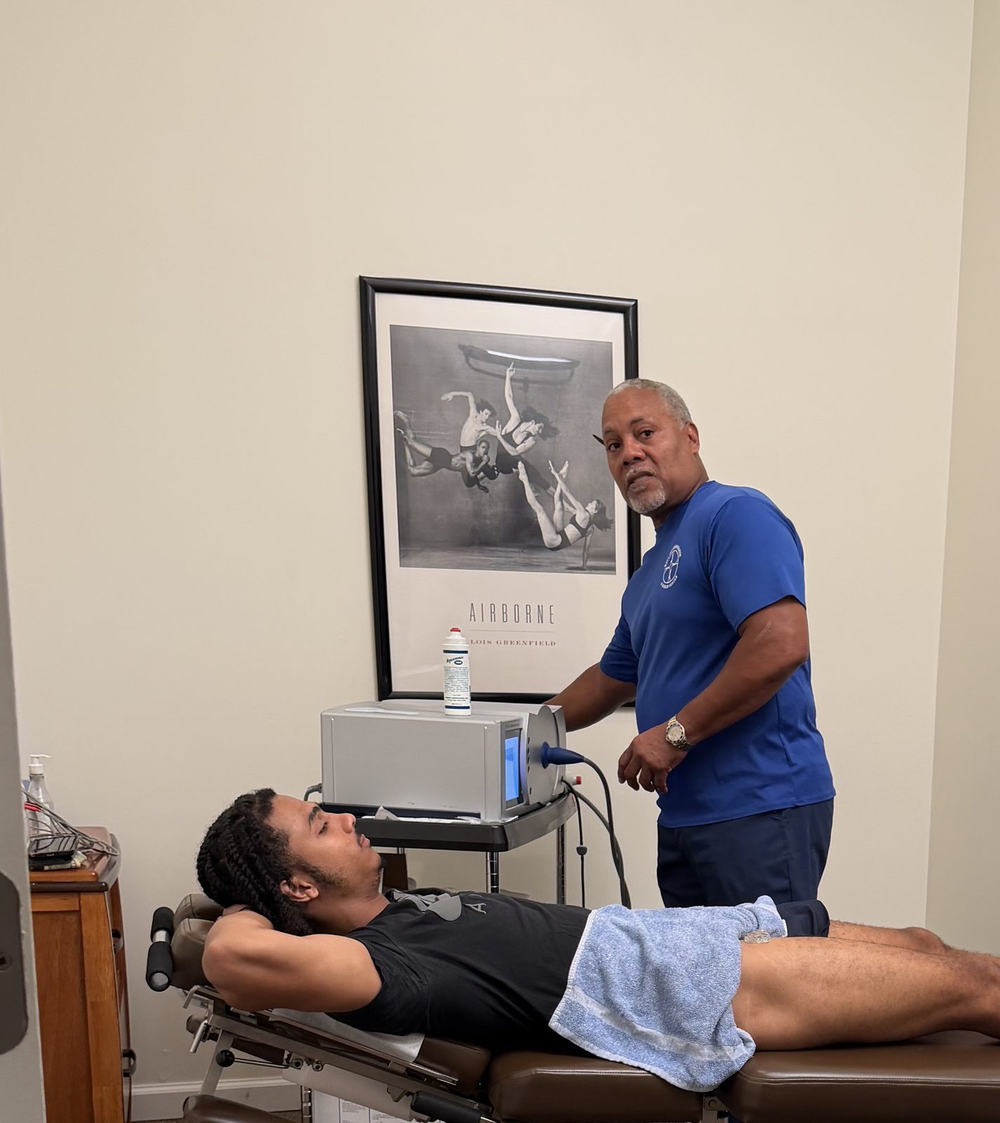 Dr. Gerdine setting up shockwave therapy for an athlete on the treatment table