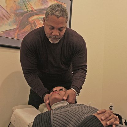 Dr. Gerdine adjusting a patient's neck on the treatment table