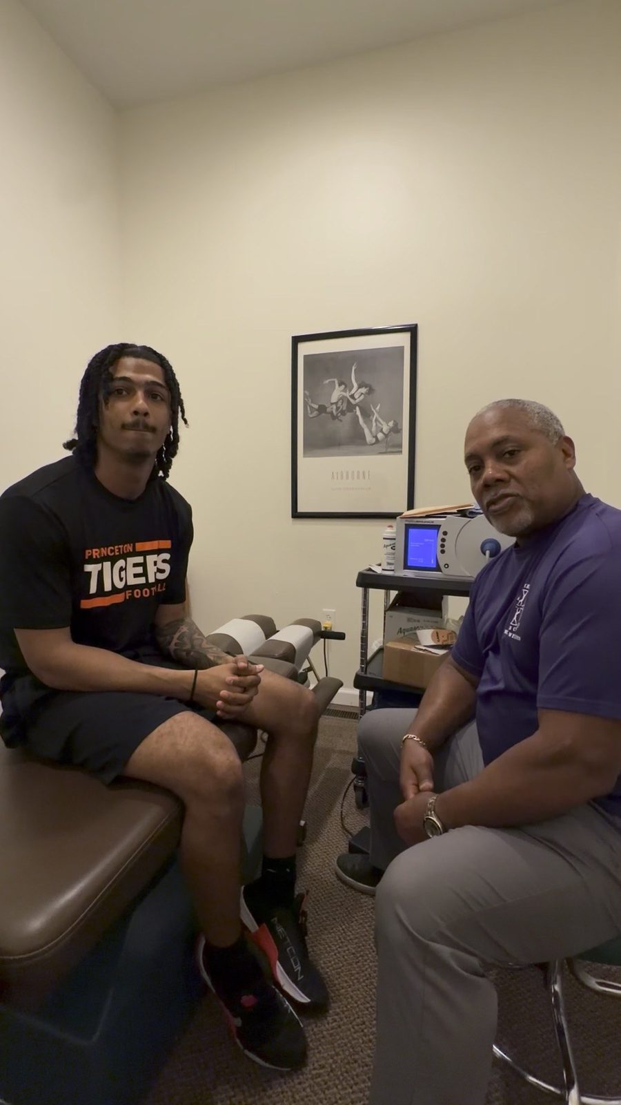 Dr. Gerdine talking with a college football player before treatment