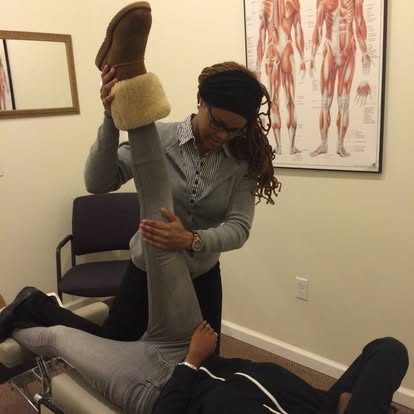 Clinician performing an assisted hamstring stretch on a patient for sciatica relief